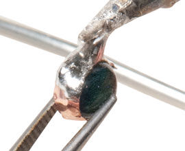 Soldering iron putting solder on bezel